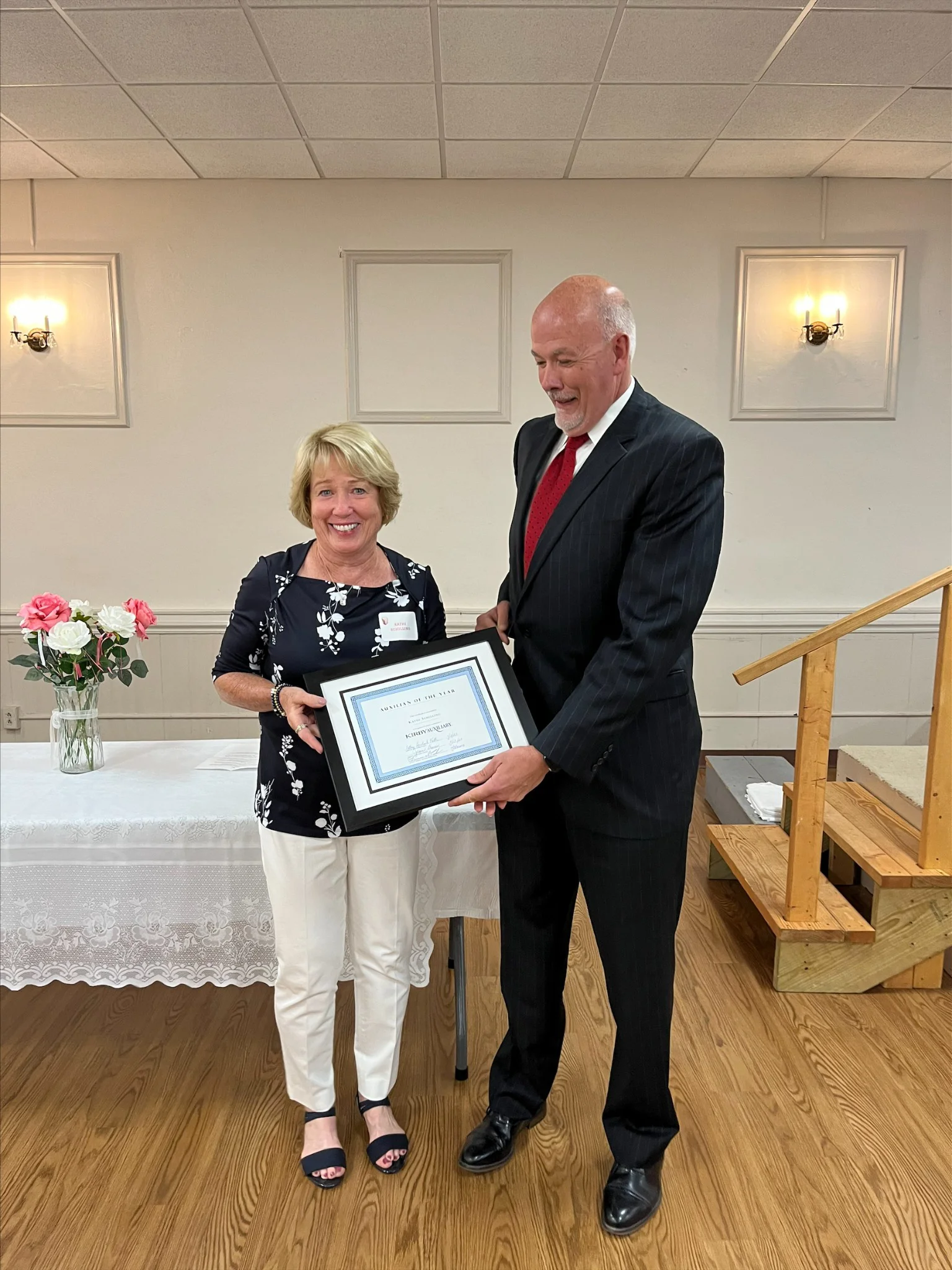 An Auxiliary member receiving a framed recognition certificate.